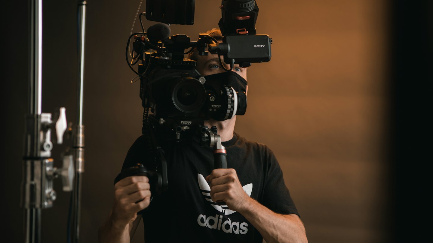 Videographer operating a cinema camera rig with monitor.
